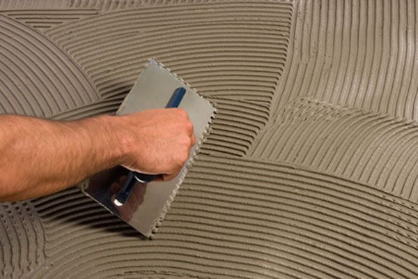 Tile adhesive being applied with a notched trowel